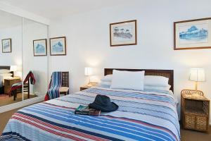 a bedroom with a bed with a hat on it at Beach House in Lennox Head