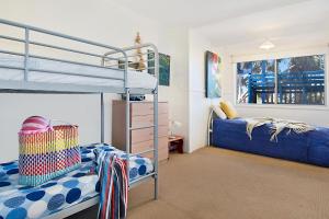 a bedroom with two bunk beds and a ladder at Beach House in Lennox Head