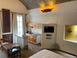 a room with a bed and a kitchen with a television at Suite vista hermosa in San Miguel de Allende