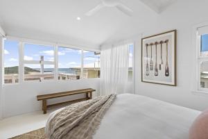 a white bedroom with a bed and a window at Walters in East Ballina