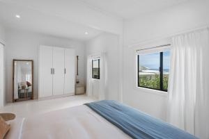 a white bedroom with a bed and a window at Walters in East Ballina +22 photos