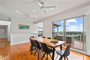 a dining room with a table and chairs and a large window at Shaws View in East Ballina