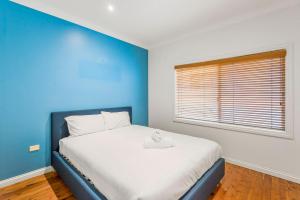 a blue bedroom with a bed with a blue wall at Shaws View in East Ballina