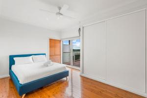a bedroom with a bed and a large window at Shaws View in East Ballina
