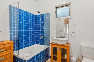 a bathroom with a tub shower and a sink at Shaws View in East Ballina +8 photos