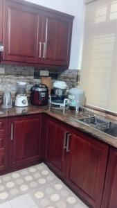 a kitchen with wooden cabinets and appliances on the counter at Serenique Greens in Kandy +24 photos