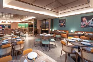 a restaurant with tables and chairs in a room at Orange Hotel Kunshan MixC Hotel in Kunshan