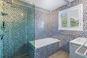 a bathroom with a shower and a tub and a sink at Stingray in Ballina