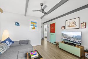 a living room with a couch and a flat screen tv at Stingray in Ballina