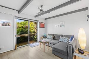 a living room with a couch and a large window at Stingray in Ballina +5 photos