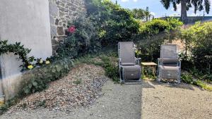 two empty chairs sitting next to a wall at La parenthèse bucolique in Cheissoux