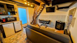 a living room with a couch and a kitchen at La parenthèse bucolique in Cheissoux