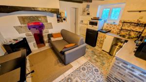 a living room with a couch and a kitchen at La parenthèse bucolique in Cheissoux +8 photos