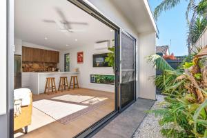 an open kitchen and living room with sliding glass doors at Blue Ash Studio in Lennox Head