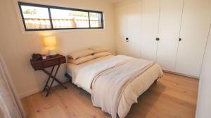 a bedroom with a bed and a table with a lamp at Blue Ash Studio in Lennox Head