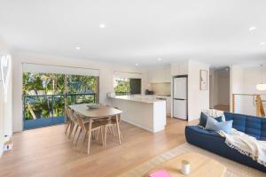 a living room and kitchen with a blue couch at Bombora in Lennox Head +11 photos
