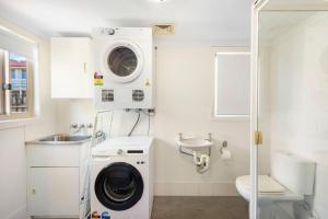a bathroom with a washing machine and a sink at Bombora in Lennox Head