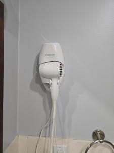 a hair dryer in a corner of a room at Cobourg Inn in Cobourg