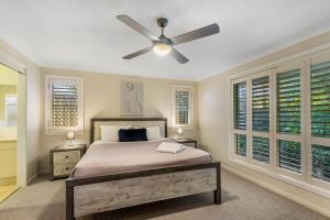 a bedroom with a bed and a ceiling fan at Frangipani Hideaway in Lennox Head +3 photos