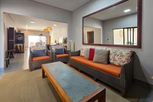 a living room with two couches and a mirror at Casa Ninhal, super central, nova e espaçosa. in Bonito