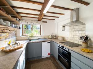 a kitchen with a sink and a stove top oven at Titchbourne Cottage in Clee Saint Margaret