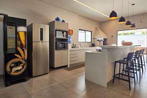 a kitchen with stainless steel appliances and a bar with stools at Casa Ninhal, super central, nova e espaçosa. in Bonito