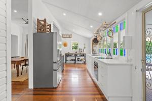 a kitchen with white counters and a dining room at Hinterland Views in Lennox Head
