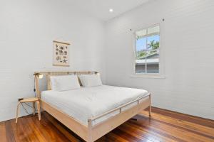a bed in a white room with a window at Hinterland Views in Lennox Head +13 photos