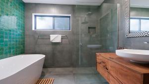 a bathroom with a tub and a sink and a shower at KK s in Lennox Head in Lennox Head +4 photos