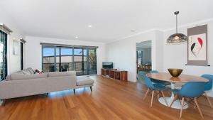 a living room with a couch and a table and chairs at KK s in Lennox Head in Lennox Head