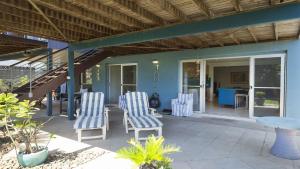 a patio with blue and white chairs and a staircase at Moana Retreat in Lennox Head +4 photos