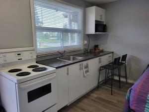 a kitchen with a white stove and a sink at Cobourg Inn in Cobourg +40 photos