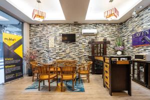 a dining room with chairs and a brick wall at Lavender Inn Permas Jaya in Johor Bahru