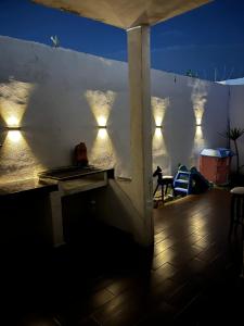 a patio with lights on a white wall at night at Casa completa, 4 dormitorios, 7 camas dobles, 4 sofá cama, 3 baños 1 en planta baja, cocina equipada, consola Arcade, asador, juguetes para niños, plancha, secadora, cafetera, etc, fraccionamiento privado, zona de vías rápidas y toallas in Torreón