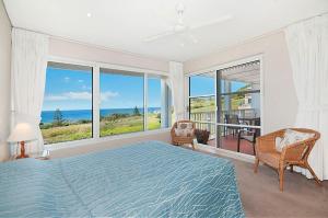 a bedroom with a bed and a view of the ocean at Quarterdeck 20 in Lennox Head