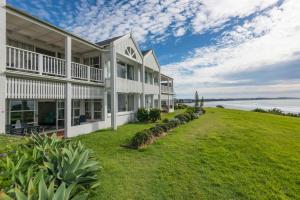 an exterior view of a large house with a lawn at Quarterdeck 18 in Lennox Head