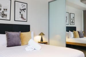 a bedroom with two beds and a mirror at Spacious Studio in a Prime Braddon Location - Hosted by Canstay in Braddon