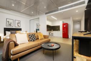 a living room with a couch and a table at Spacious Studio in a Prime Braddon Location - Hosted by Canstay in Braddon