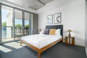 a bedroom with a bed and a large window at Spacious Studio in a Prime Braddon Location - Hosted by Canstay in Braddon