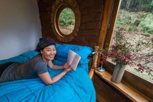 een vrouw die in een bed een boek leest bij The Roundhouse in Jackeys Marsh