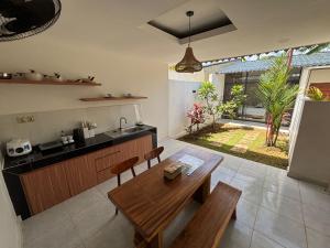 a kitchen with a wooden table and a dining room at Kotoa Villa 68 in Nusa Dua