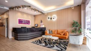 a lobby with an orange couch and a table at Lavender Inn Permas Jaya in Johor Bahru