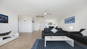 a living room with a black couch and a table at Quarterdeck 23 in Lennox Head