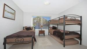 two bunk beds in a room with a window at Quarterdeck 23 in Lennox Head