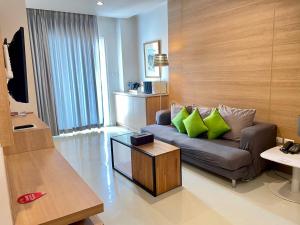a living room with a couch with green pillows at Korapura Resort in Nakhon Ratchasima