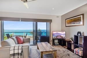 a living room with a couch and a table at Surf Sea and Sand in East Ballina