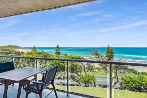 a balcony with a table and chairs overlooking the ocean at Surf Sea and Sand in East Ballina