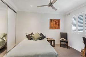 a bedroom with a bed and a ceiling fan at Surf Sea and Sand in East Ballina