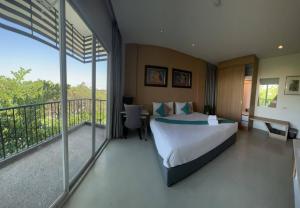 a bedroom with a bed and a balcony at Korapura Resort in Nakhon Ratchasima