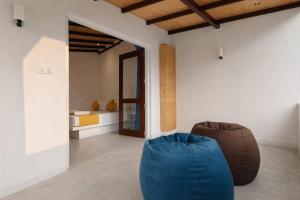 a living room with a blue chair and a bed at Paragon Villa Madiha in Matara